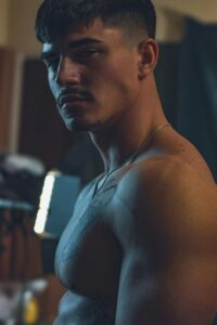 Artistic portrait of a muscular man with dramatic lighting and a moody ambiance.